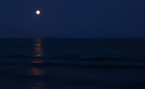 Scenic view of sea against clear sky at night