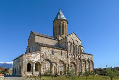 Low angle view of historic building against clear blue sky