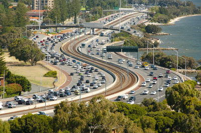 High angle view of vehicles on road amidst trees in city