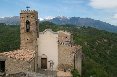 Historic church by mountains against sky in roccascalegna