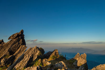 Panoramic view of rocks and mountains against clear blue sky