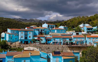 Houses in town against cloudy sky