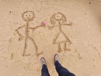 Low section of person on sand at beach