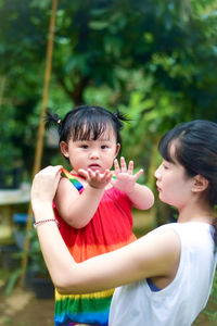 Side view of mother carrying daughter