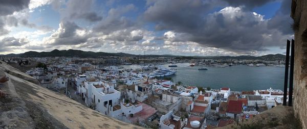 Panoramic view of sea and cityscape against sky