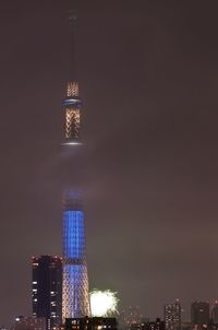 Low angle view of illuminated tower against sky at night