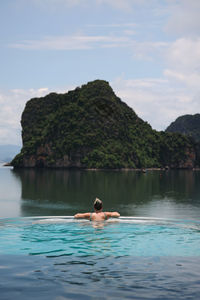 Man swimming in sea against sky