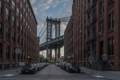 View of city street against manhattan bridge 