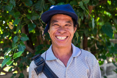 Close-up portrait of smiling man against trees