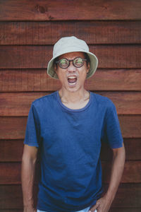 Asian man wearing clothes hat acting wow with funny face
