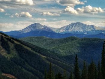 Scenic view of field and mountains against sky