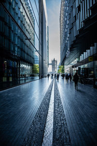 City street by modern buildings against sky