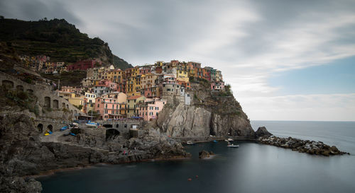 Panoramic view of buildings by sea against sky