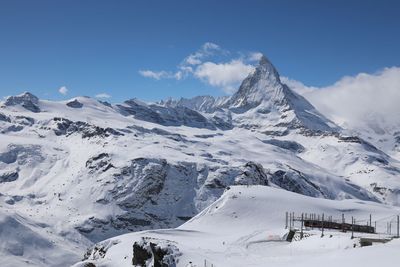 Scenic view of snow covered mountains against sky