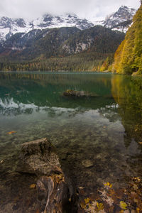 Scenic view of lake by mountains against sky