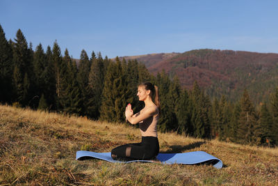 Young girl doing yoga fitness exercise outdoor in beautiful mountains landscape. morning sunrise,