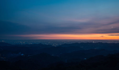 Scenic view of silhouette mountains against sky during sunset