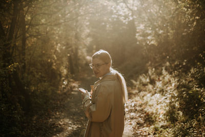 A young woman walking in the woods during autumn