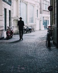 Full length of man with bicycle on road in city