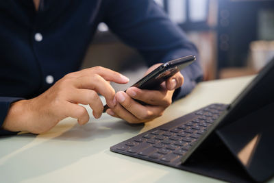 Midsection of man using laptop on table