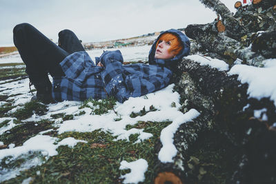 Woman lying on snow covered land