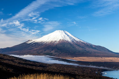 Scenic view of snowcapped mountains against blue sky