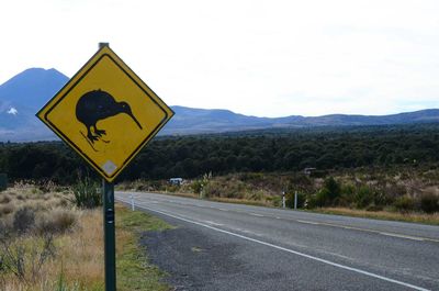 Road signs on landscape against sky