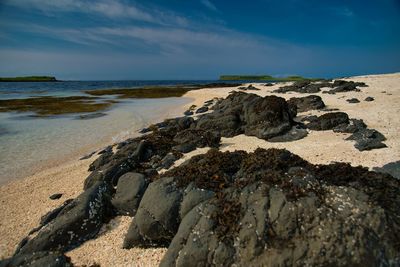 Scenic view of rocks on beach against sky