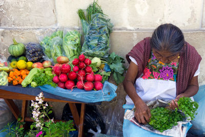 Woman with vegetables in market stall
