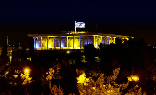 Illuminated city against sky at night