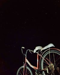 Low angle view of bicycle against sky at night