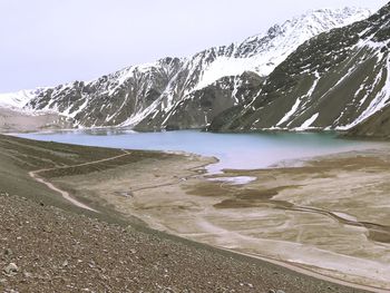 Scenic view of lake by mountains against clear sky