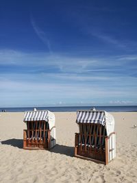 Chairs on beach against sky