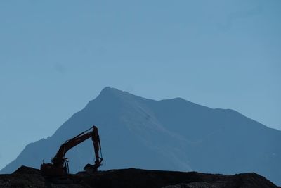 Silhouette mountain range against clear blue sky