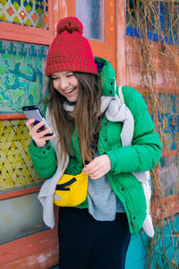 Full length of young woman holding mobile phone