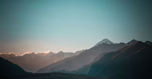 Scenic view of snowcapped mountains against sky during sunset