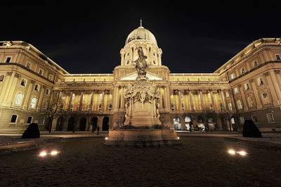 Low angle view of illuminated buda castle against clear sky at night