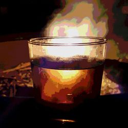 Close-up of lit candle in dark room