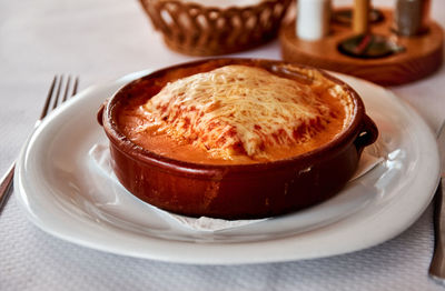 Close-up of baked lasagna in bowl on table at restaurant