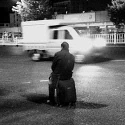 Rear view of man standing on street at night