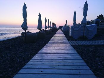 Pier over sea against sky during sunset