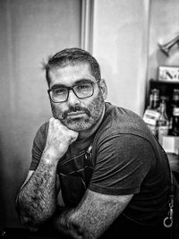 Portrait of man wearing eyeglasses while sitting at home