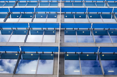 Low angle view of sky reflecting modern glass building