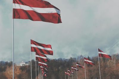 Low angle view of flag flags against sky