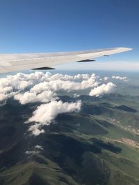 Airplane flying over mountains in sky