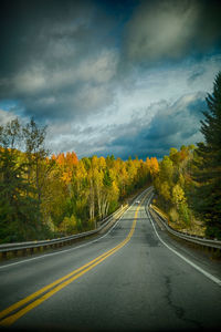 Empty road against cloudy sky
