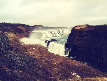 Scenic view of waterfall against sky