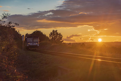 Cars on road against sky during sunset