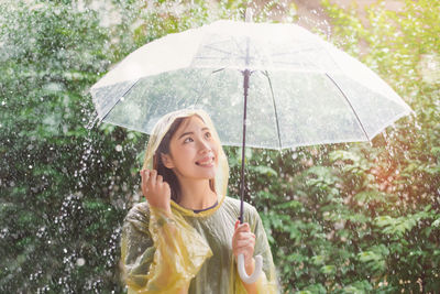 Portrait of beautiful woman standing on wet rainy day