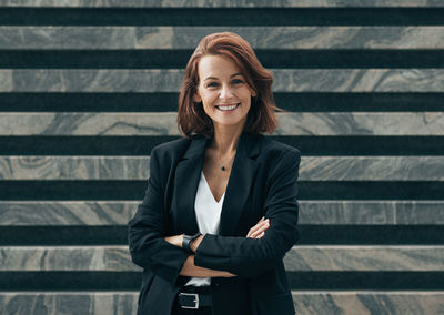 Young woman standing against corrugated iron